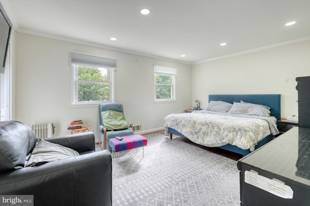 bedroom with radiator, recessed lighting, crown molding, wood finished floors, and baseboards