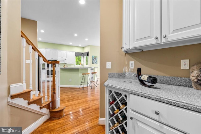 3747 Spicebush Dr, Frederick, MD 21704 - indoor dry bar with light wood-style floors, stairway, recessed lighting, white microwave, and baseboards