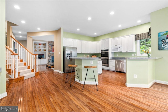 3747 Spicebush Dr, Frederick, MD 21704 - kitchen with appliances with stainless steel finishes, white cabinets, a kitchen breakfast bar, a kitchen island, and recessed lighting