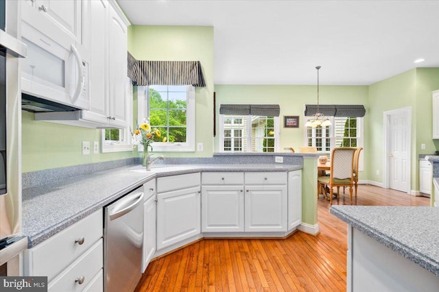 3747 Spicebush Dr, Frederick, MD 21704 - kitchen featuring stainless steel dishwasher, white microwave, light countertops, light wood-type flooring, and white cabinets