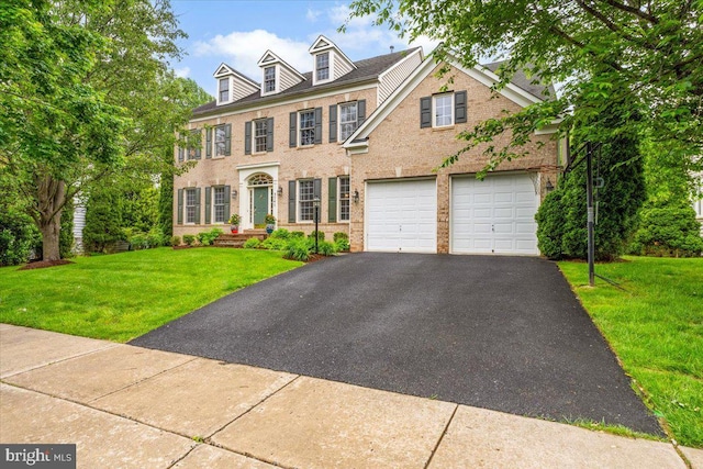 3747 Spicebush Dr, Frederick, MD 21704 - colonial home featuring brick siding, asphalt driveway, a front yard, and an attached garage