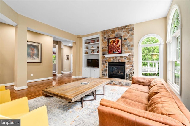 3747 Spicebush Dr, Frederick, MD 21704 - living area with wood finished floors, baseboards, a stone fireplace, and built in features