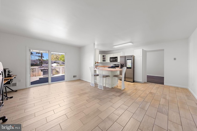 316 Nautilus Dr, Manahawkin, NJ 08050 - kitchen featuring stainless steel appliances, a kitchen bar, a peninsula, white cabinets, and light wood-type flooring