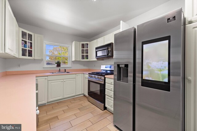 316 Nautilus Dr, Manahawkin, NJ 08050 - kitchen with stainless steel appliances, a sink, light countertops, glass insert cabinets, and white cabinetry