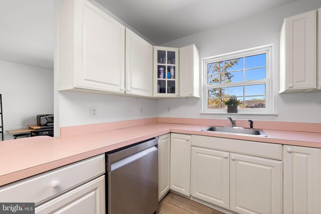 316 Nautilus Dr, Manahawkin, NJ 08050 - kitchen featuring stainless steel dishwasher, a sink, light countertops, white cabinets, and glass insert cabinets