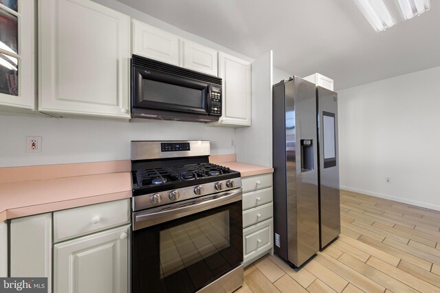 316 Nautilus Dr, Manahawkin, NJ 08050 - kitchen featuring stainless steel appliances, light countertops, white cabinets, light wood-style floors, and baseboards