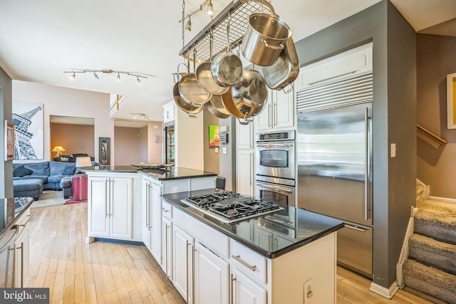 22 Sawgrass Dr, Mount Holly, NJ 08060 - kitchen with stainless steel appliances, a kitchen island, light wood finished floors, open floor plan, and white cabinets