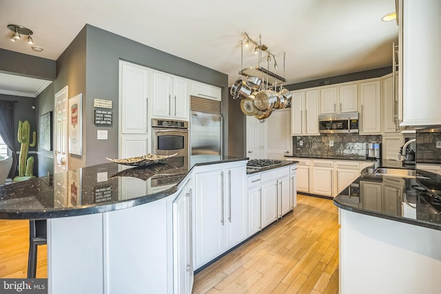 22 Sawgrass Dr, Mount Holly, NJ 08060 - kitchen with appliances with stainless steel finishes, a sink, tasteful backsplash, a center island, and light wood-style floors
