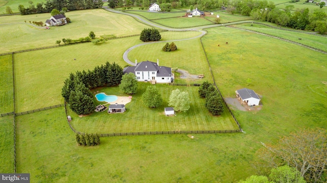 aerial view of sparsely populated area featuring a pool area and a pastoral area