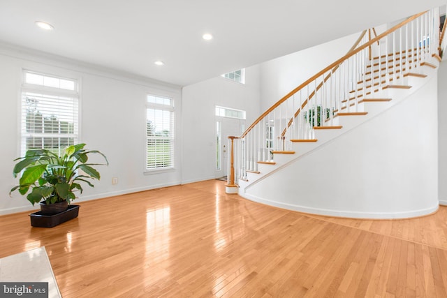 entryway with plenty of natural light, wood finished floors, stairway, baseboards, and recessed lighting