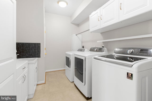 washroom with washer and clothes dryer, cabinet space, and baseboards