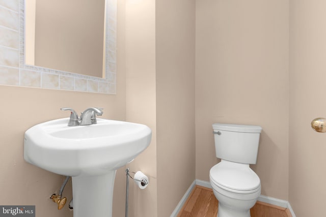 bathroom featuring wood finished floors, toilet, and baseboards