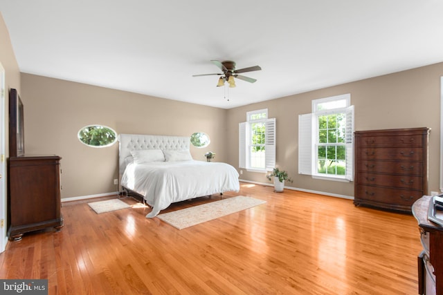 bedroom featuring light wood finished floors, baseboards, and ceiling fan
