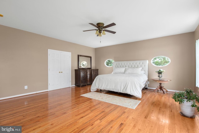 bedroom with light wood-type flooring, baseboards, and a ceiling fan