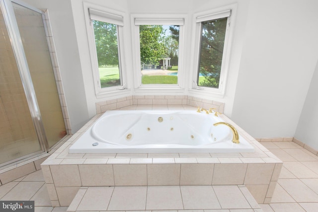bathroom featuring a shower stall, a whirlpool tub, and tile patterned floors