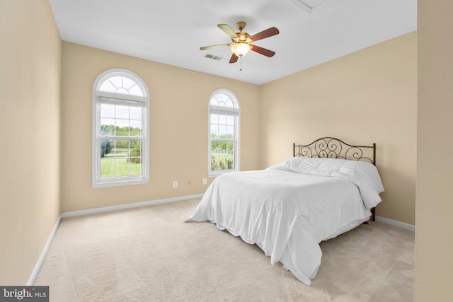 carpeted bedroom with multiple windows, baseboards, and ceiling fan