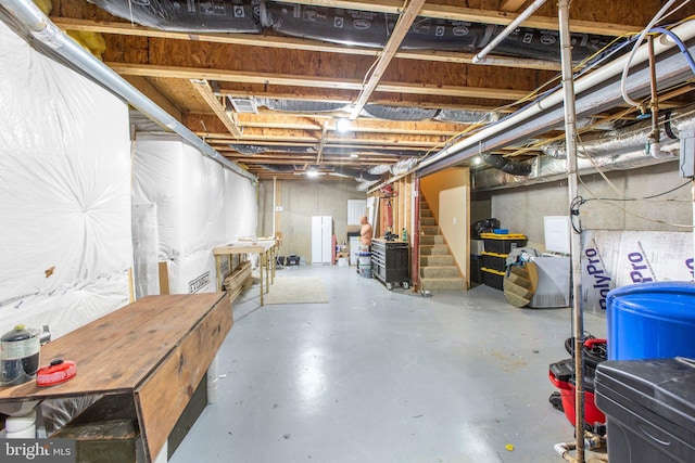 unfinished basement featuring stairway and a water pressure tank