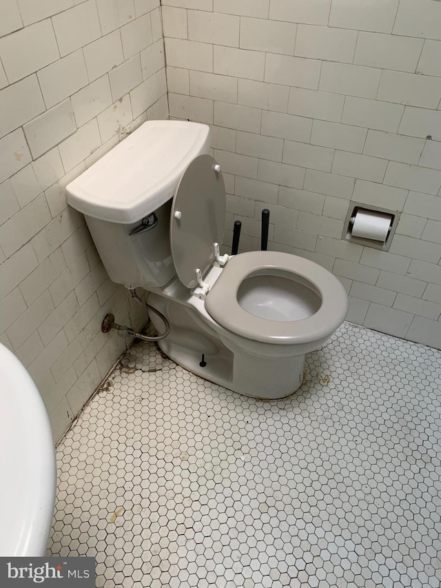 bathroom featuring tile walls, toilet, and tile patterned floors