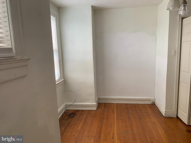 spare room featuring hardwood / wood-style flooring, plenty of natural light, and baseboards