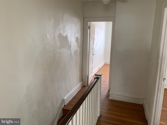 corridor with wood finished floors and baseboards