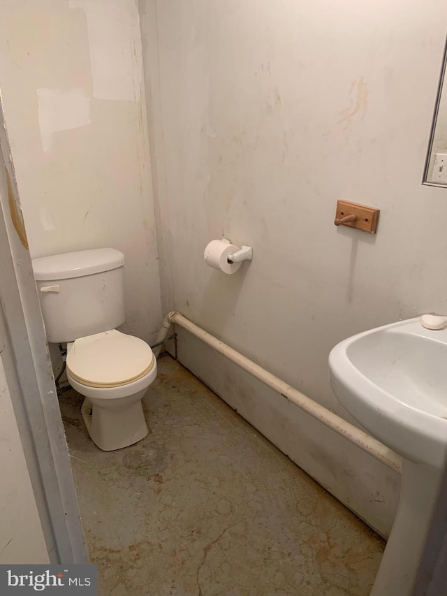 half bathroom with toilet and concrete floors