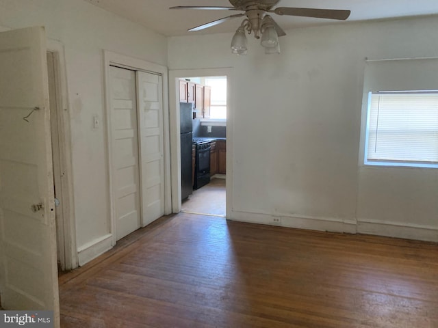 unfurnished room with a ceiling fan, light wood-style flooring, and baseboards