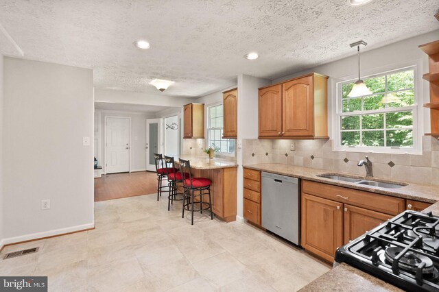 kitchen featuring dishwasher, a sink, decorative backsplash, baseboards, and recessed lighting