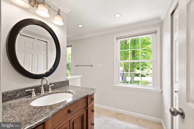 bathroom with baseboards, plenty of natural light, vanity, tile patterned flooring, and ornamental molding