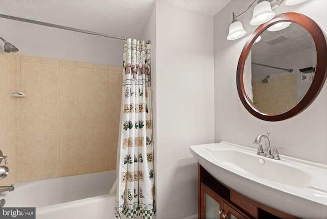 full bathroom with shower / bath combo with shower curtain, a textured ceiling, and vanity