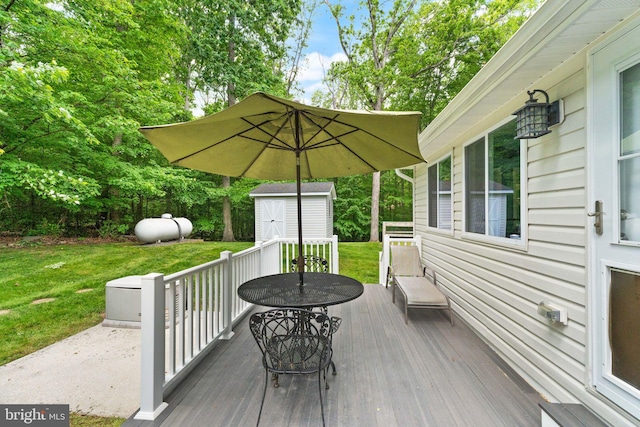 wooden deck featuring a storage unit, an outbuilding, and a yard