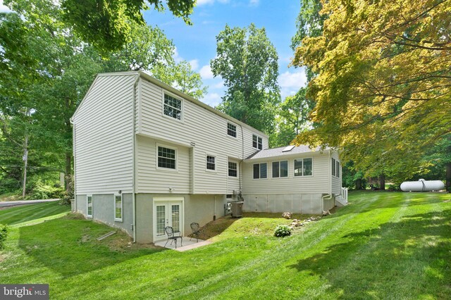 back of house with french doors, a lawn, and central air condition unit