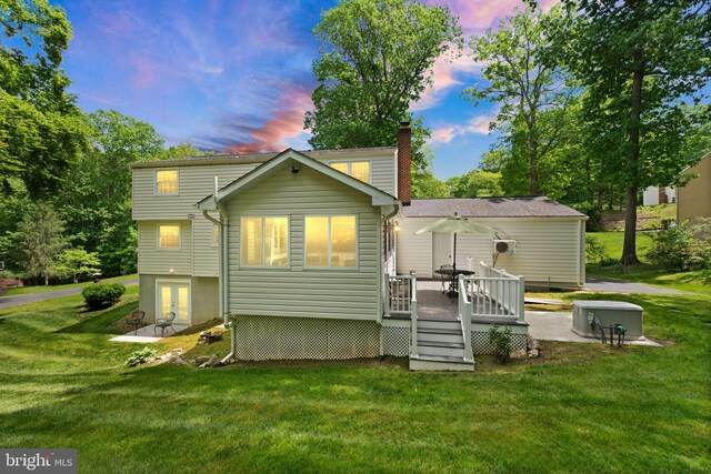 rear view of house with a wooden deck, a lawn, a chimney, and french doors