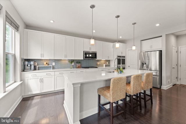 kitchen with stainless steel appliances, backsplash, light countertops, dark wood-style floors, and recessed lighting