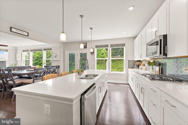kitchen with a sink, stainless steel appliances, dark wood finished floors, plenty of natural light, and recessed lighting