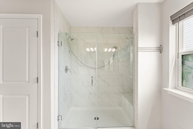 bathroom featuring a marble finish shower