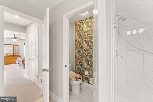 full bathroom with a shower stall, toilet, baseboards, a ceiling fan, and marble look tiles