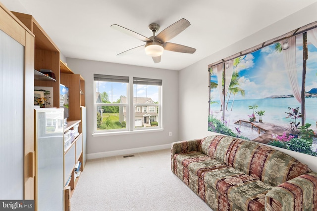 living area with baseboards, a ceiling fan, light colored carpet, and a water view