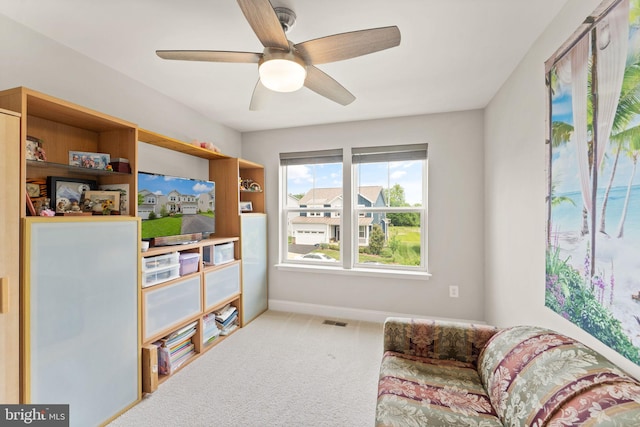 sitting room with carpet floors, baseboards, and ceiling fan