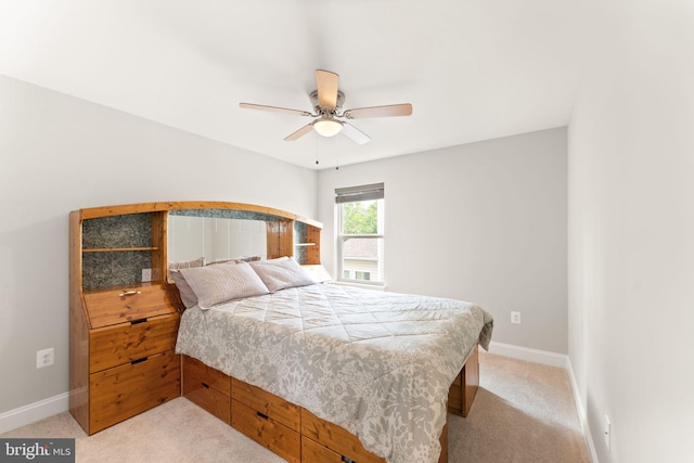 bedroom featuring light colored carpet, baseboards, and ceiling fan
