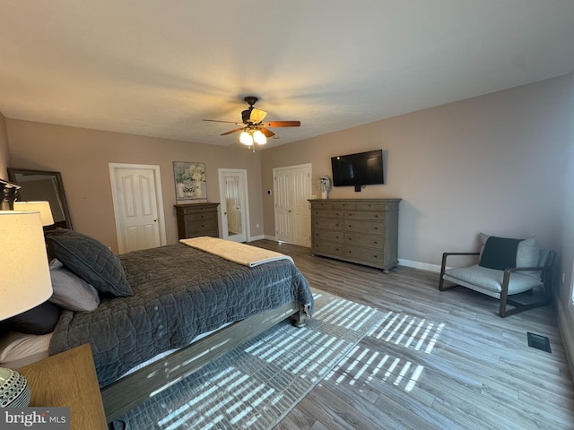 9420 River View Rd, Broomes Island, MD 20615 - bedroom with baseboards, wood finished floors, two closets, and a ceiling fan