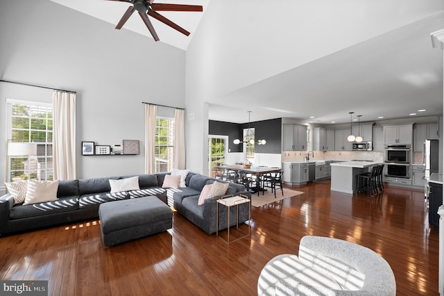 living room featuring ceiling fan, dark wood-type flooring, healthy amount of natural light, high vaulted ceiling, and recessed lighting