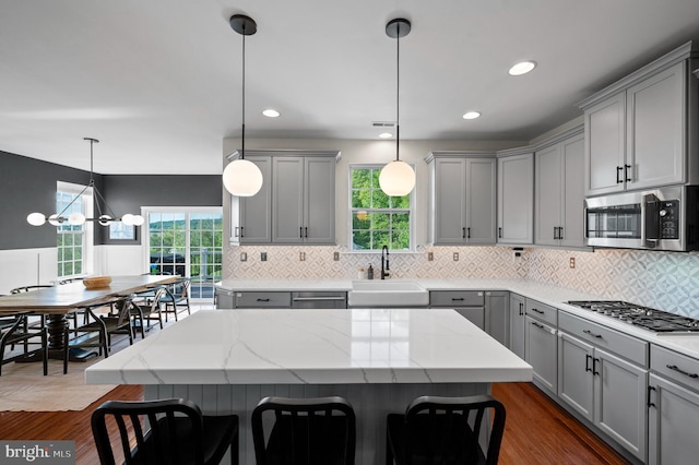 kitchen with gray cabinetry, stainless steel appliances, a sink, healthy amount of natural light, and recessed lighting