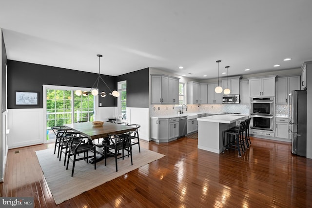 dining room featuring a chandelier, wainscoting, dark wood-style floors, and recessed lighting