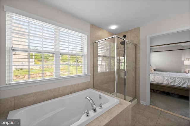 full bathroom with ensuite bath, a shower stall, a garden tub, and tile patterned flooring