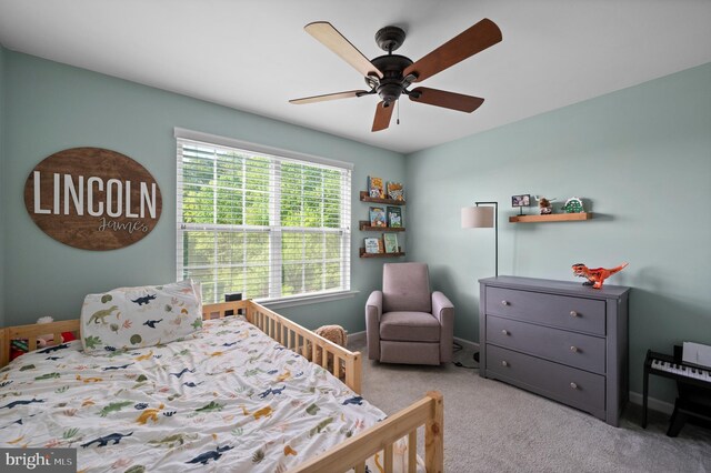 carpeted bedroom with baseboards and a ceiling fan
