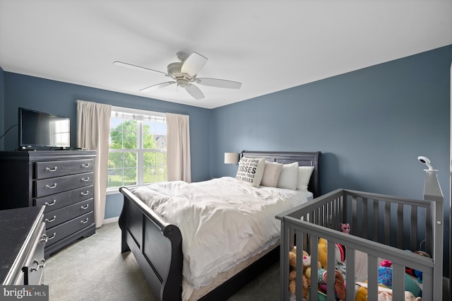 bedroom featuring light carpet, a ceiling fan, and baseboards