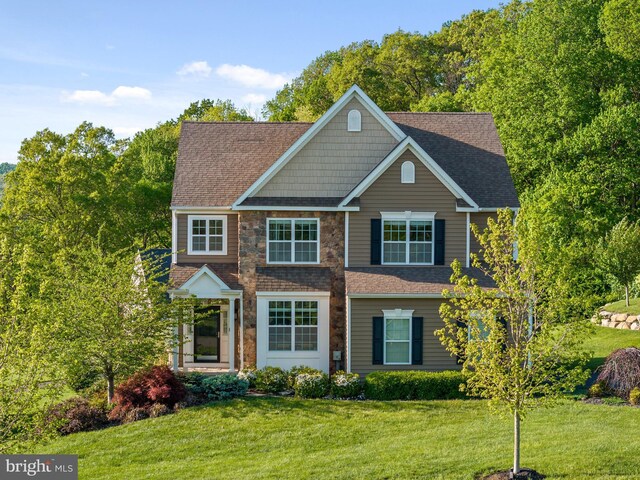 view of front of property with a front yard and a shingled roof