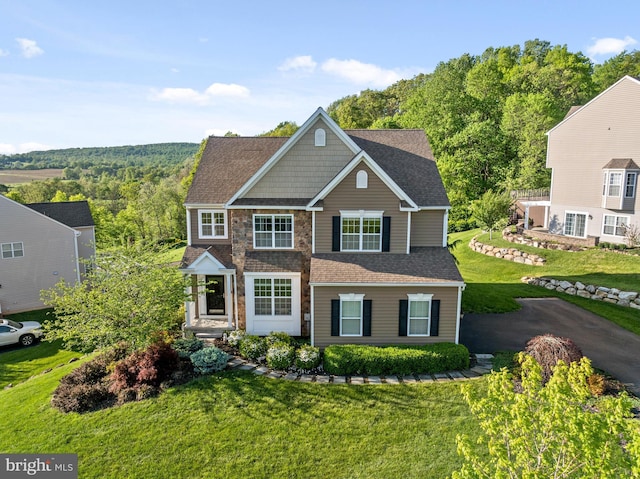 view of front of house with a front lawn and roof with shingles
