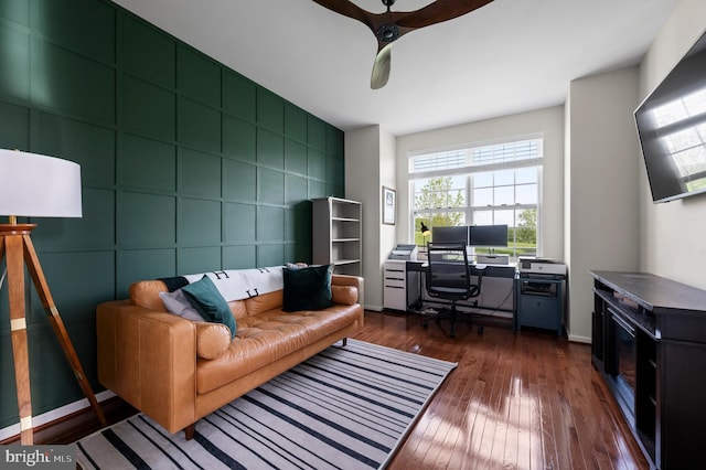 office space with dark wood-type flooring, a ceiling fan, and baseboards