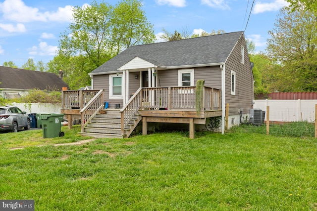 view of front facade with a shingled roof, a wooden deck, and central air condition unit
